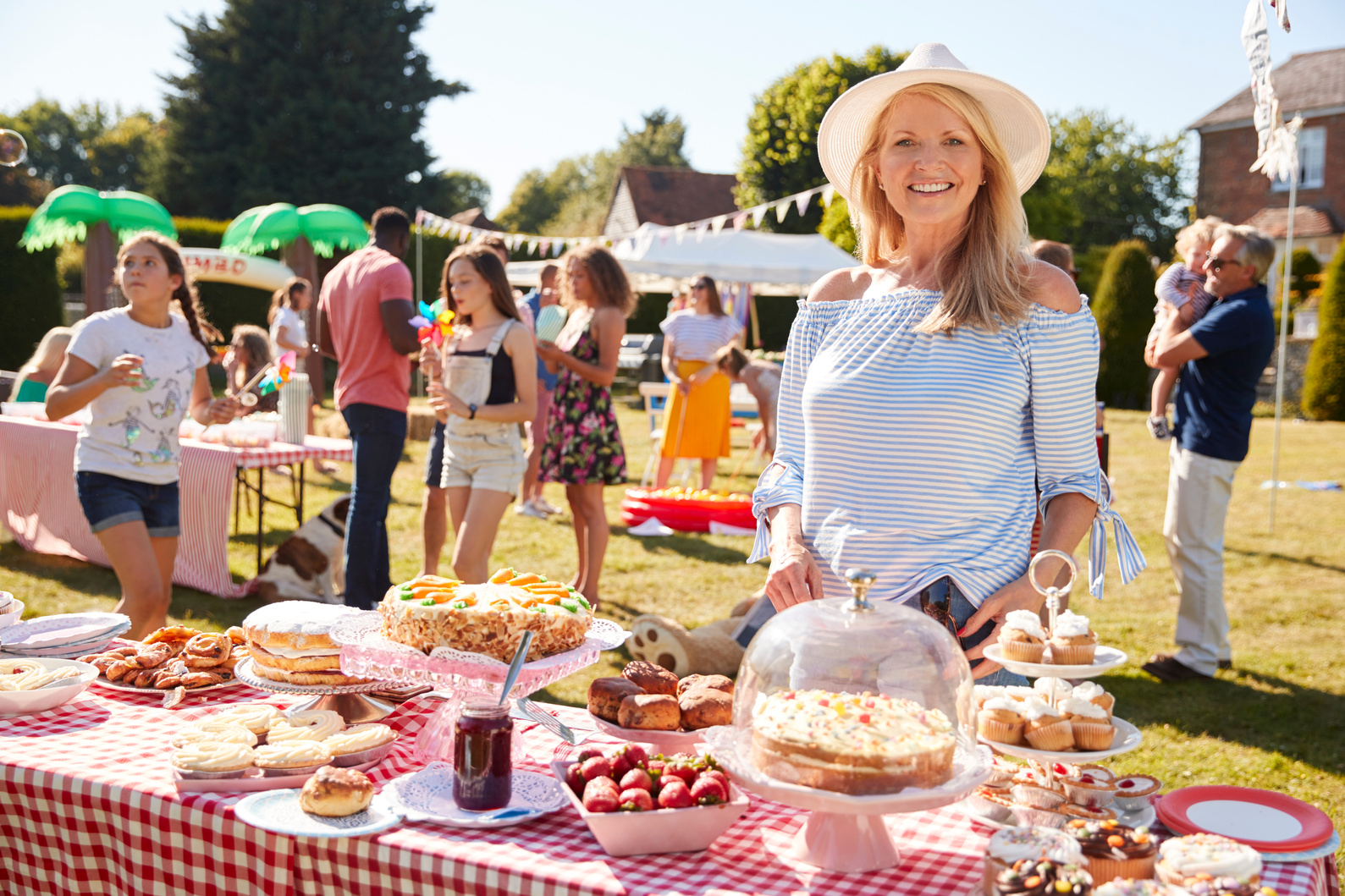 Portrait of Mature Woman Serving on Cake Stall at Busy Summer Ga